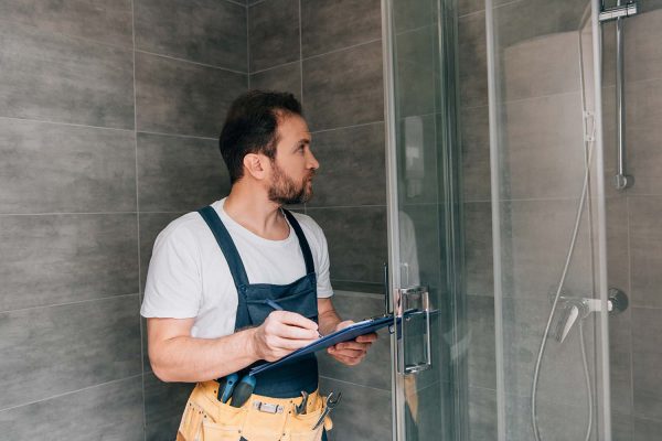 adult male plumber making notes in clipboard while resize