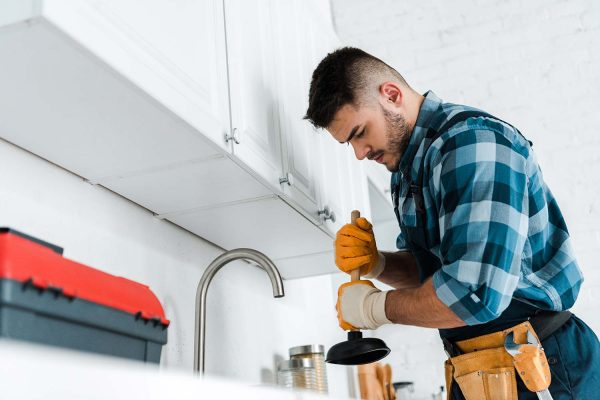 selective focus of repairman holding plunger in ki resize